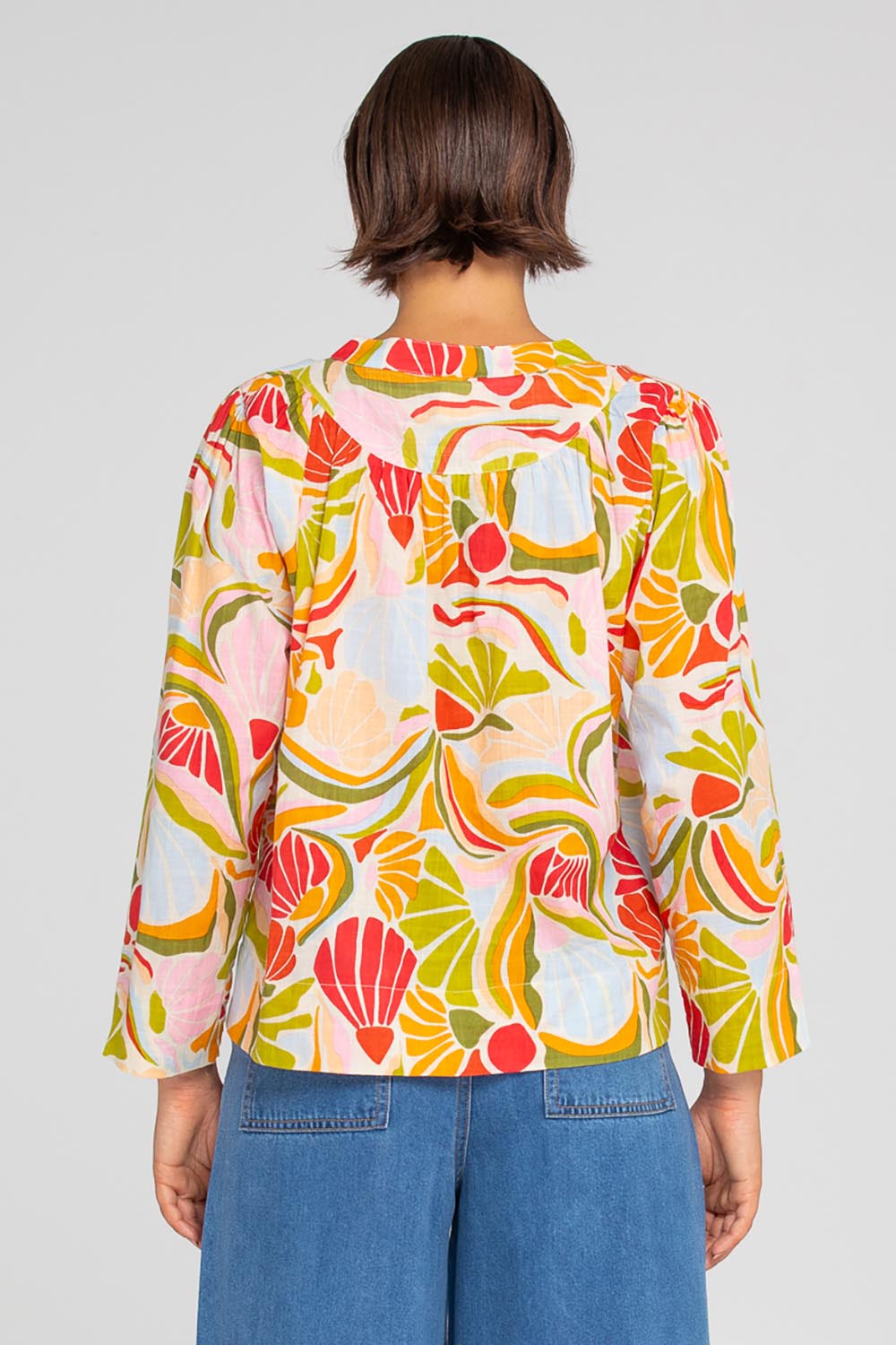 A model wearing the Hannah Cotton Top in colour Colada (Green), from the back