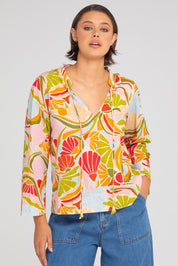 A model wearing the Hannah Cotton Top in colour Colada (Green), from the front, cropped image