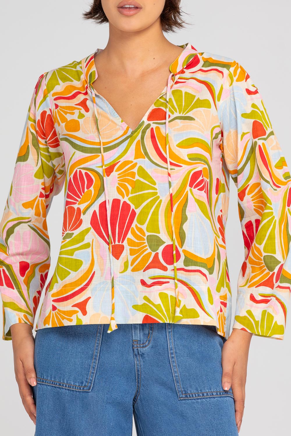A model wearing the Hannah Cotton Top in colour Colada (Green), from the front, cropped image