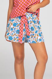 A model wearing the Daisy Cotton Short in colour Splicemaui (Blue), from the front, cropped image