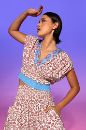 A model wearing the Desi Cotton Top in colour Paradise, from the front, showing the whole outfit
