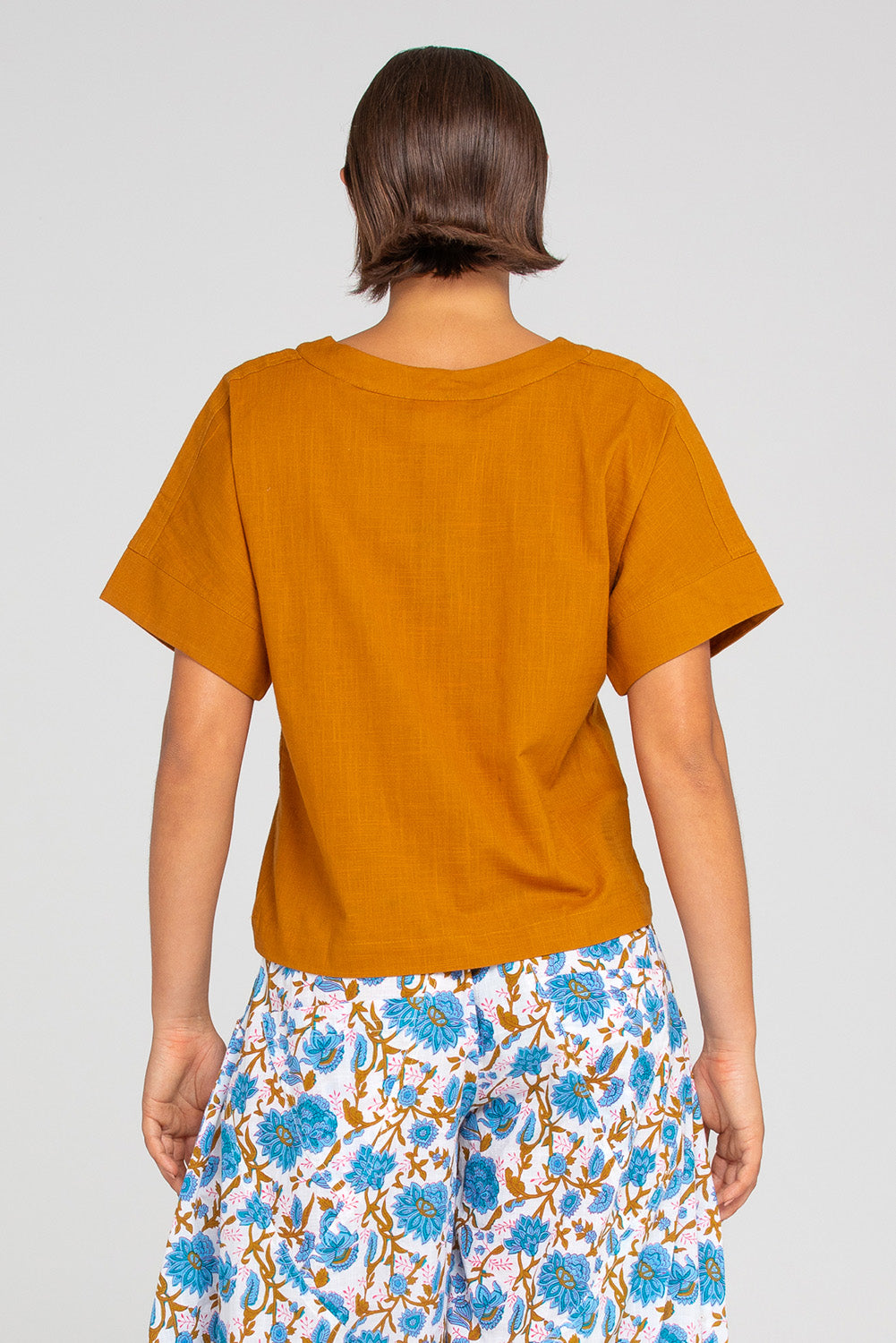 A model wearing the Haven Cotton Top in colour Mustard, from the back