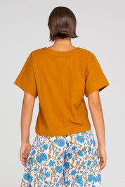 A model wearing the Haven Cotton Top in colour Mustard, from the back