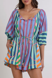 Model Madeline wearing size 10 of the Lucia Cotton Playsuit in colour Capris, from the front, cropped image