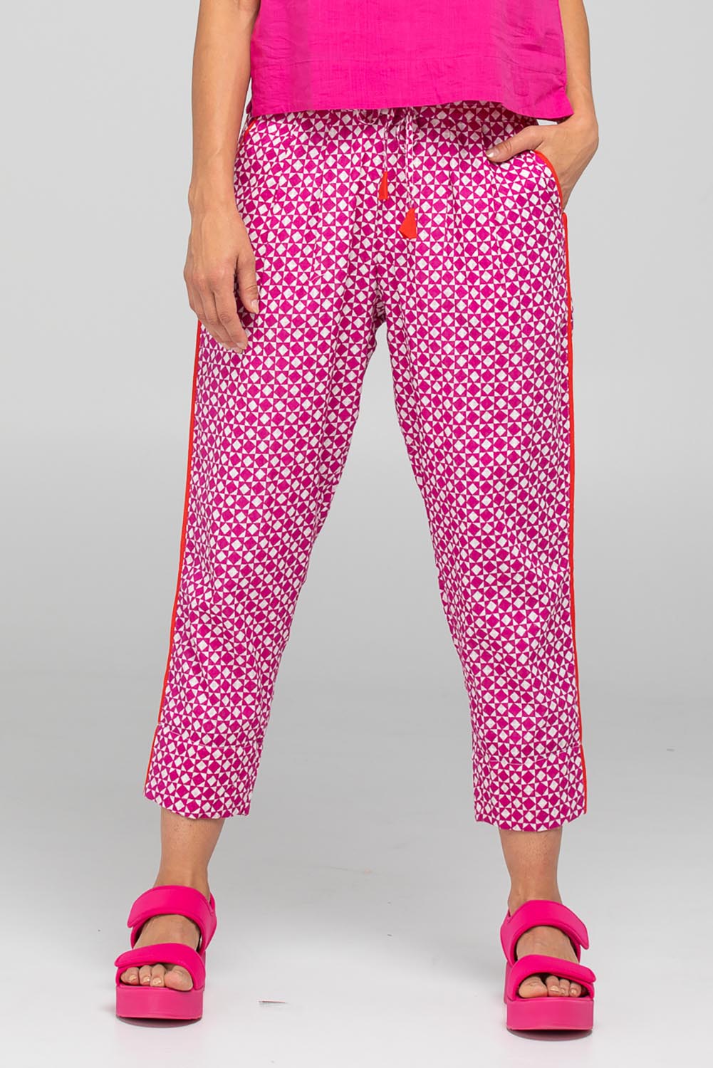 A model wearing the Kelsey Cotton Pant in colour Naples (Pink), from the front, cropped image