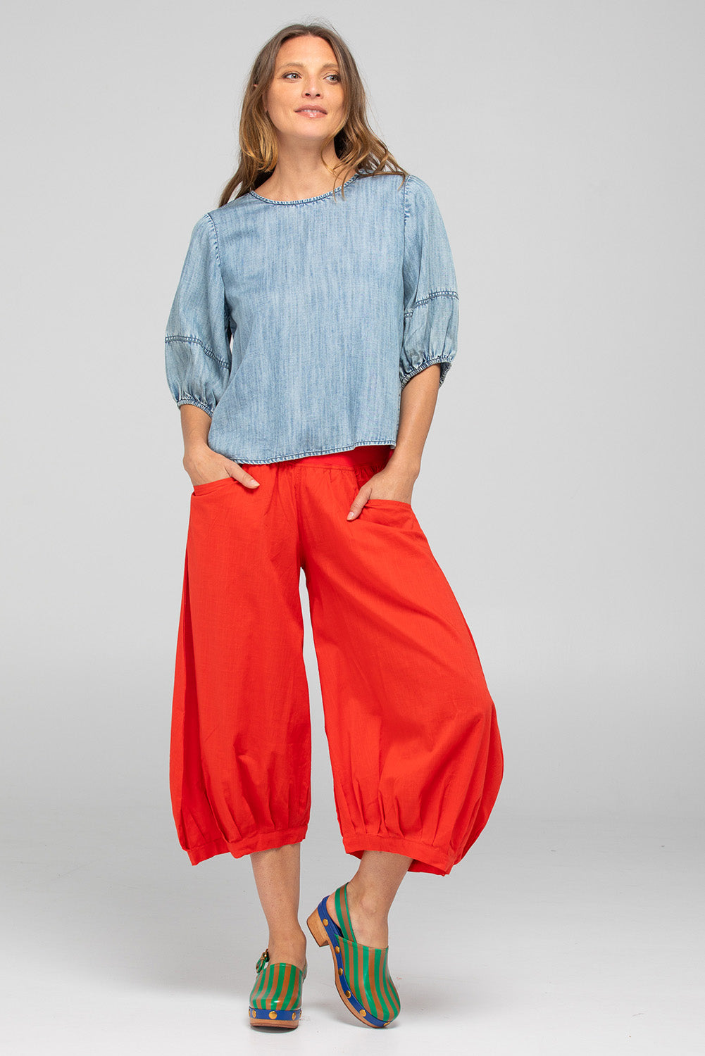 A model wearing the Guru Cotton Pant in colour Pomodoro (Red), from the front, showing the whole outfit