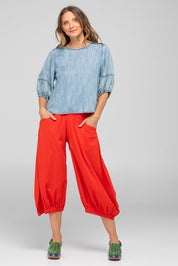 A model wearing the Guru Cotton Pant in colour Pomodoro (Red), from the front, showing the whole outfit