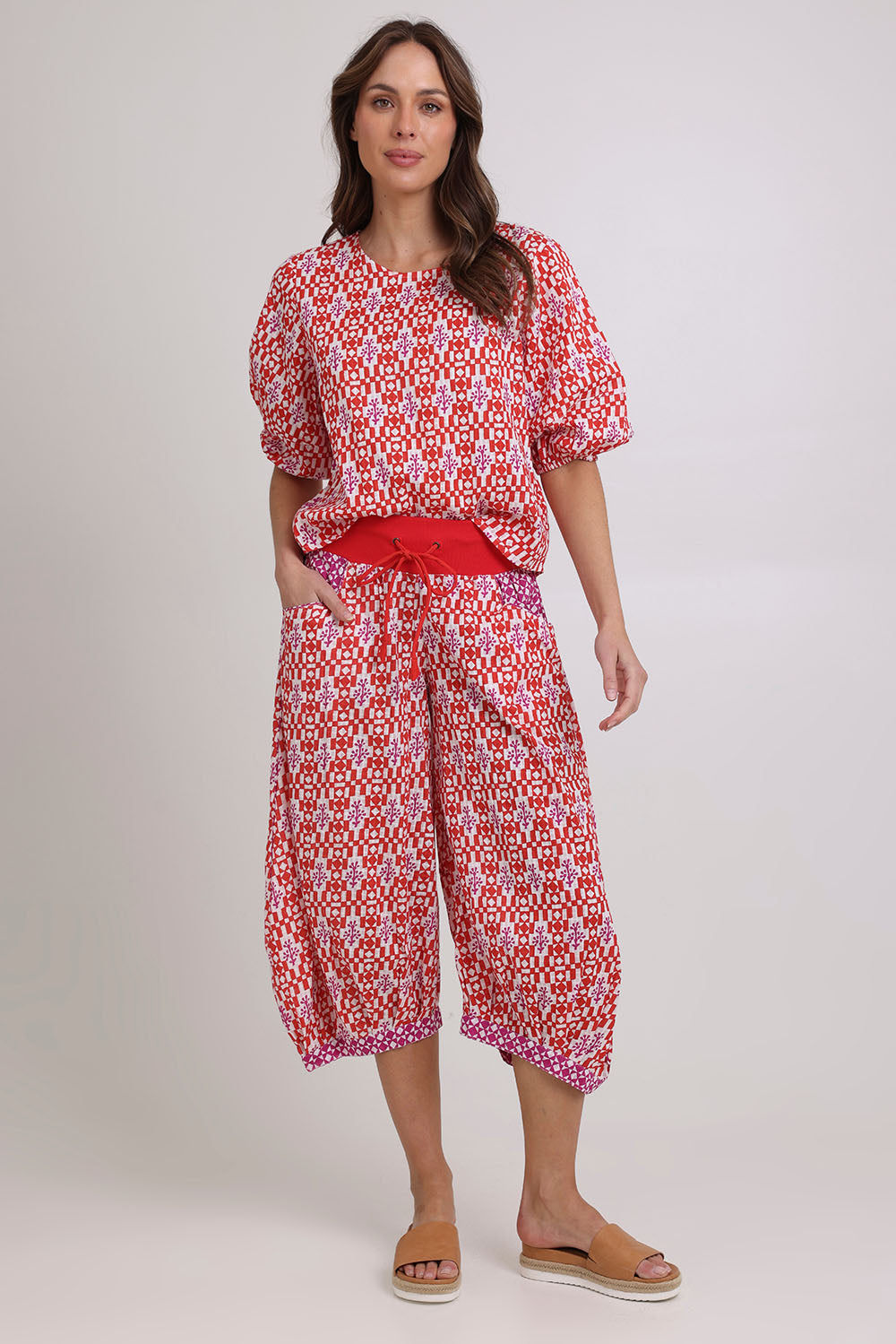 Model Madeline wearing size 10 of the Guru Cotton Pant in colour Naples (Pink), from the front, showing the whole outfit
