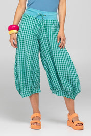 A model wearing the Guru Cotton Pant in colour Green (Green), from the front, cropped image