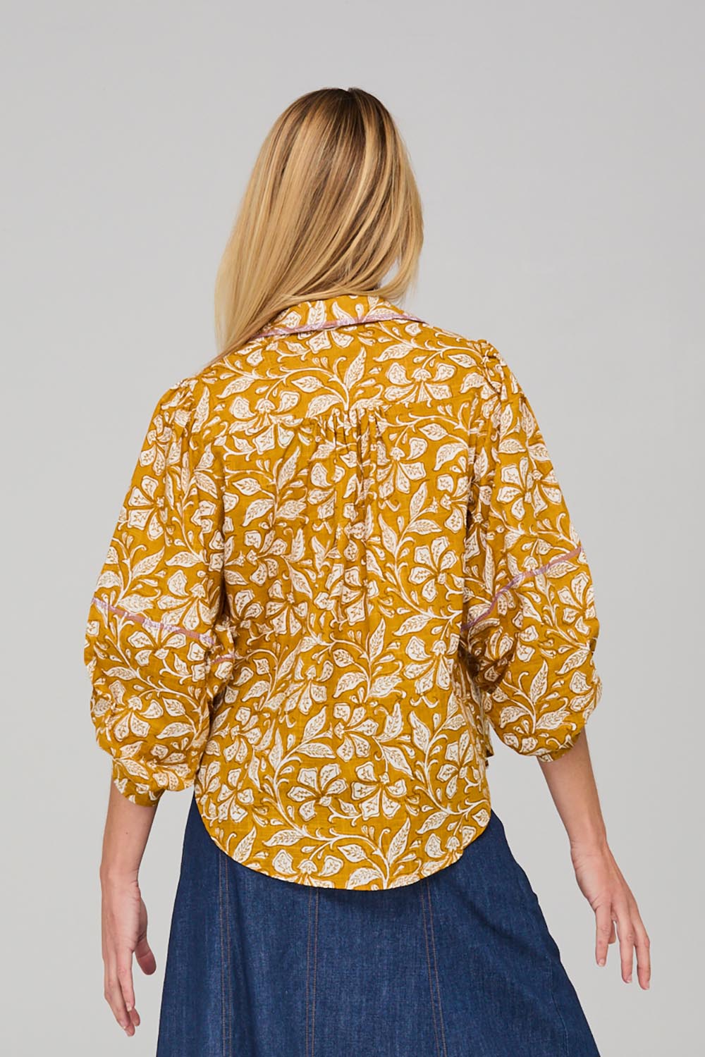 A model wearing the Pari Shirt in colour Mustard, from the back