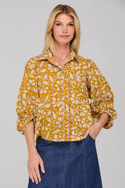 A model wearing the Pari Shirt in colour Mustard, from the front, cropped image