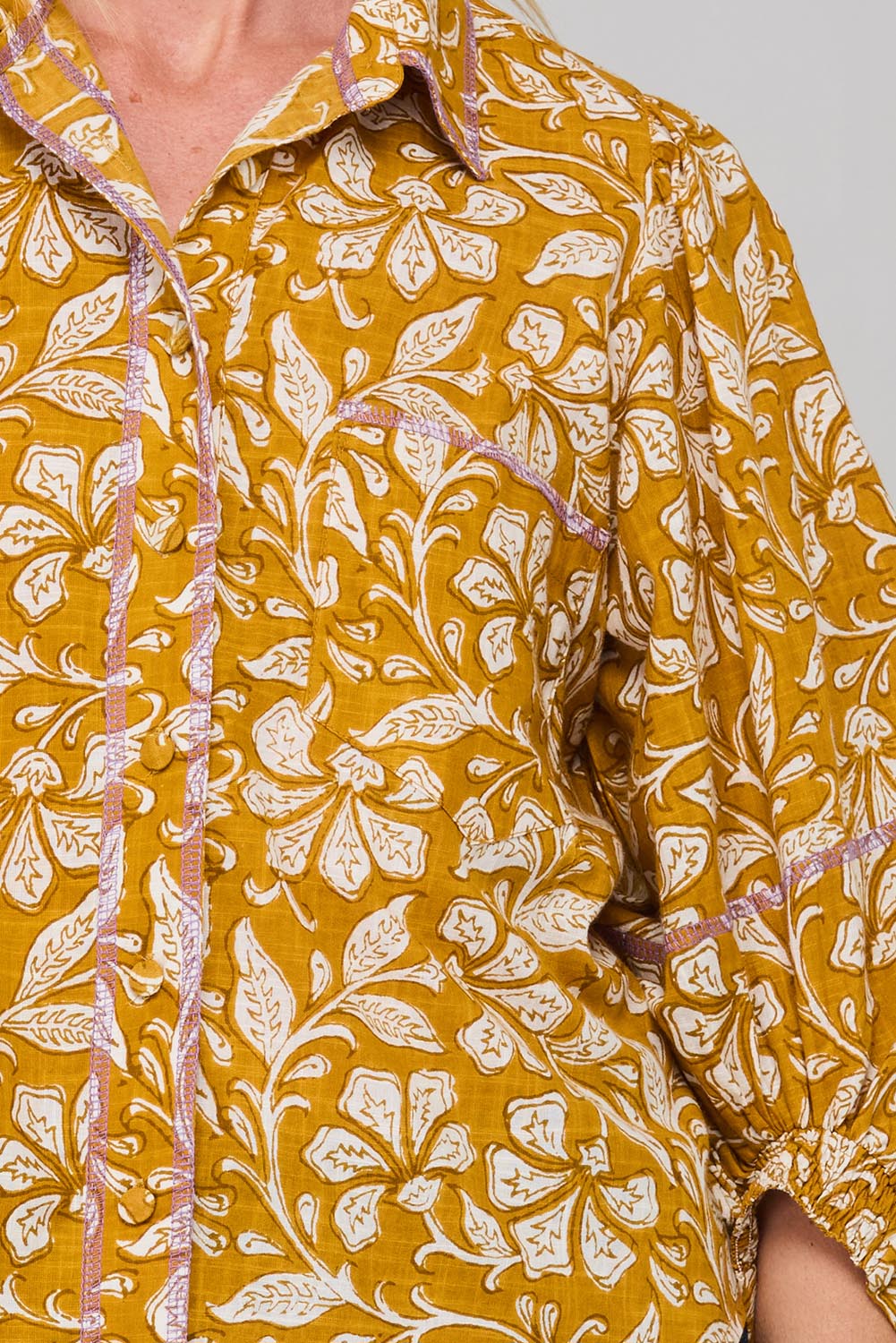 A model wearing the Pari Shirt in colour Mustard, from the front, cropped image