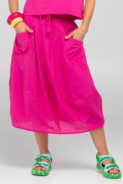 A model wearing the Guru Cotton Skirt in colour Fiore (Pink), from the front, cropped image
