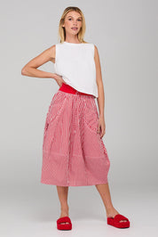 A model wearing the Guru Cotton Skirt in colour Emilias (Red), from the front, showing the whole outfit
