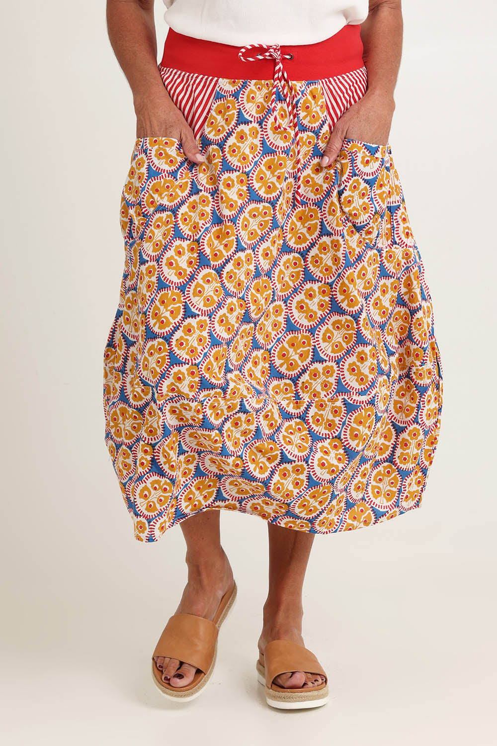 Model Sandy wearing size 10 of the Guru Cotton Skirt in colour Emiliab, from the front, cropped image