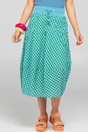 A model wearing the Guru Cotton Skirt in colour Green (Green), from the front, cropped image