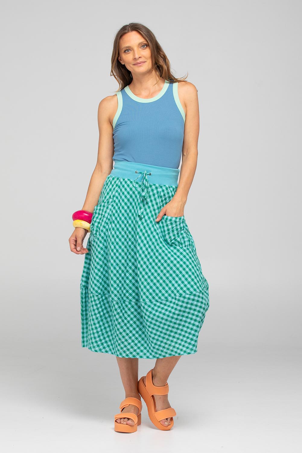 A model wearing the Guru Cotton Skirt in colour Green (Green), from the front, showing the whole outfit