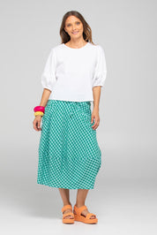 A model wearing the Guru Cotton Skirt in colour Green (Green), from the front, showing the whole outfit