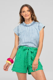 A model wearing the Hazel Cotton Short in colour Verde (Green), from the front, cropped image