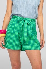 A model wearing the Hazel Cotton Short in colour Verde (Green), from the front, cropped image