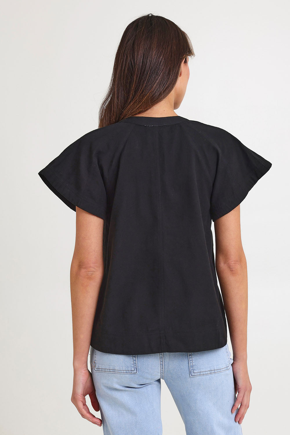 Model Madeline wearing size 10 of the Livy Cotton Top in colour Black (Black), from the back