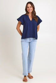 Model Madeline wearing size 10 of the Livy Cotton Top in colour Navy (Blue), from the front, showing the whole outfit