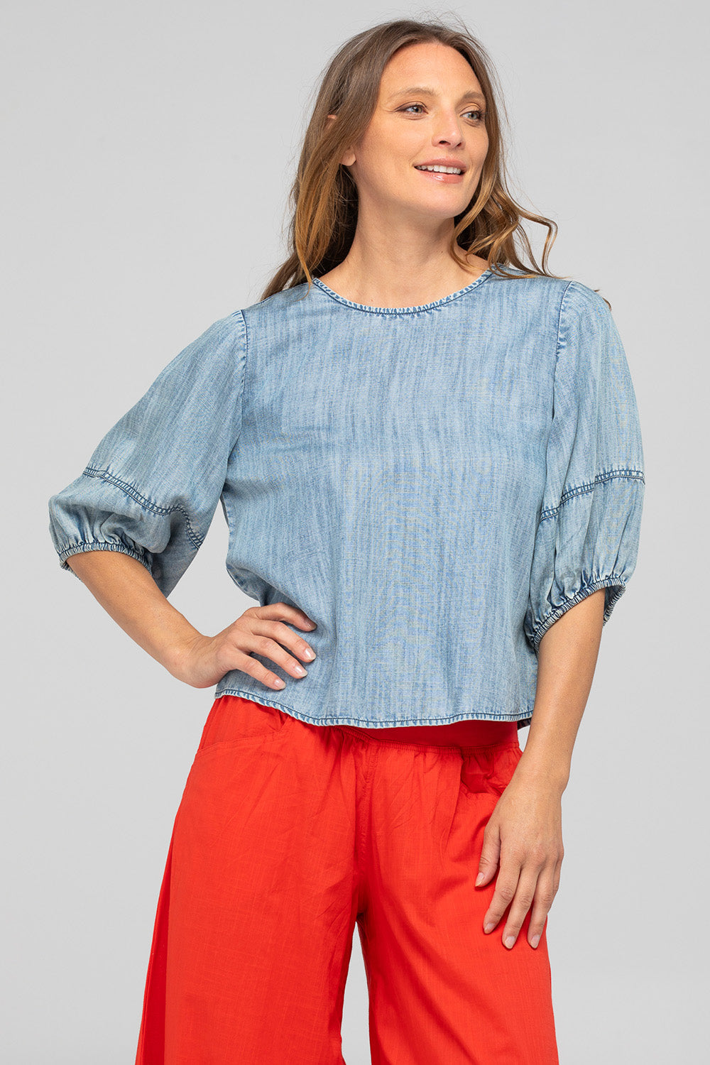 A model wearing the Ava Lyocell Top in colour Comoda (Blue), from the front, cropped image