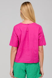 A model wearing the Guru Cotton Top in colour Fiore (Pink), from the back