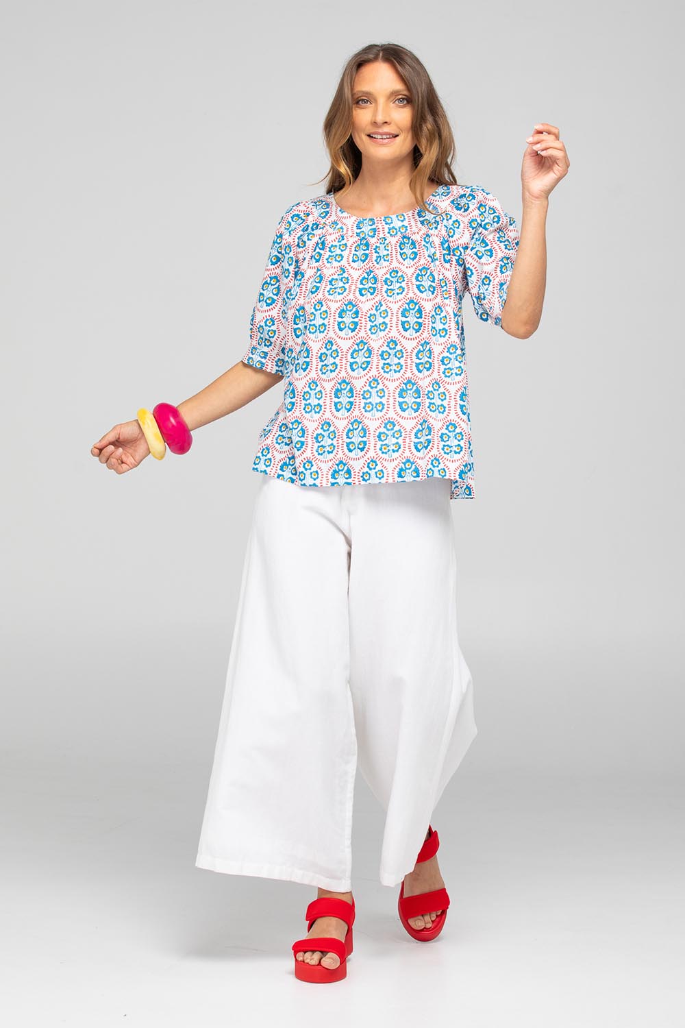A model wearing the Bliss Cotton Top in colour Emiliaw (Blue), from the front, showing the whole outfit