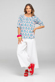 A model wearing the Bliss Cotton Top in colour Emiliaw (Blue), from the front, showing the whole outfit