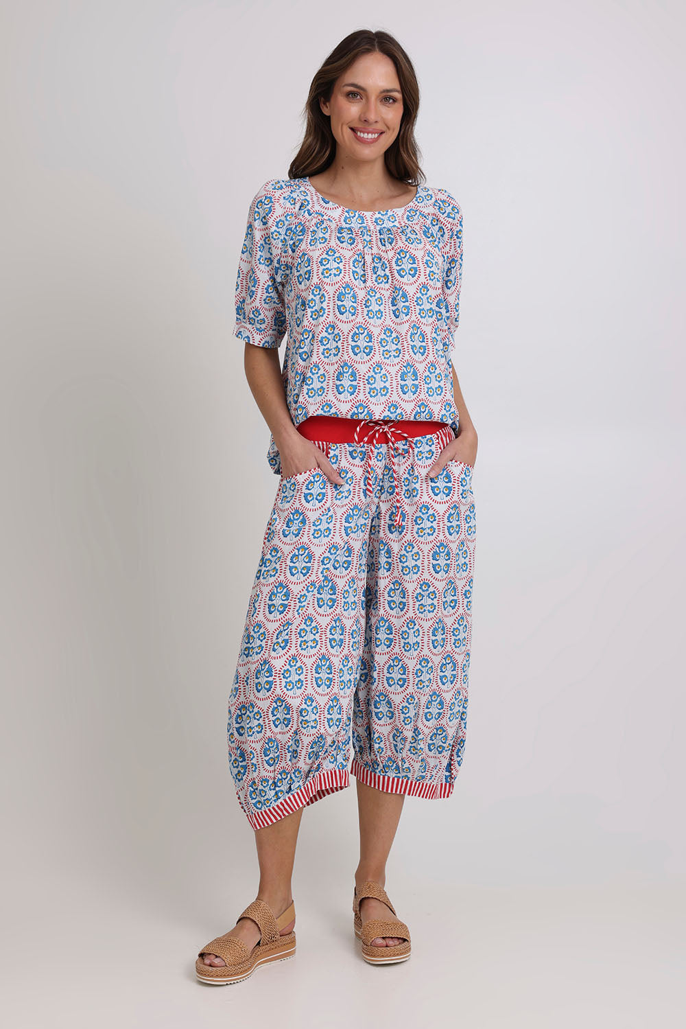 Model Madeline wearing size 10 of the Bliss Cotton Top in colour Emiliaw (Blue), from the front, showing the whole outfit