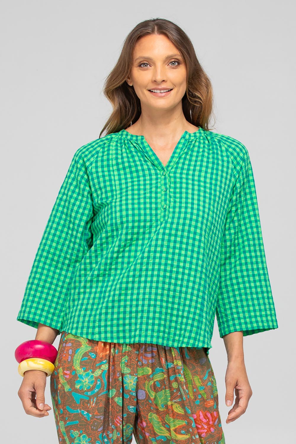 A model wearing the Cecilia Cotton Top in colour Verde (Green), from the front, cropped image