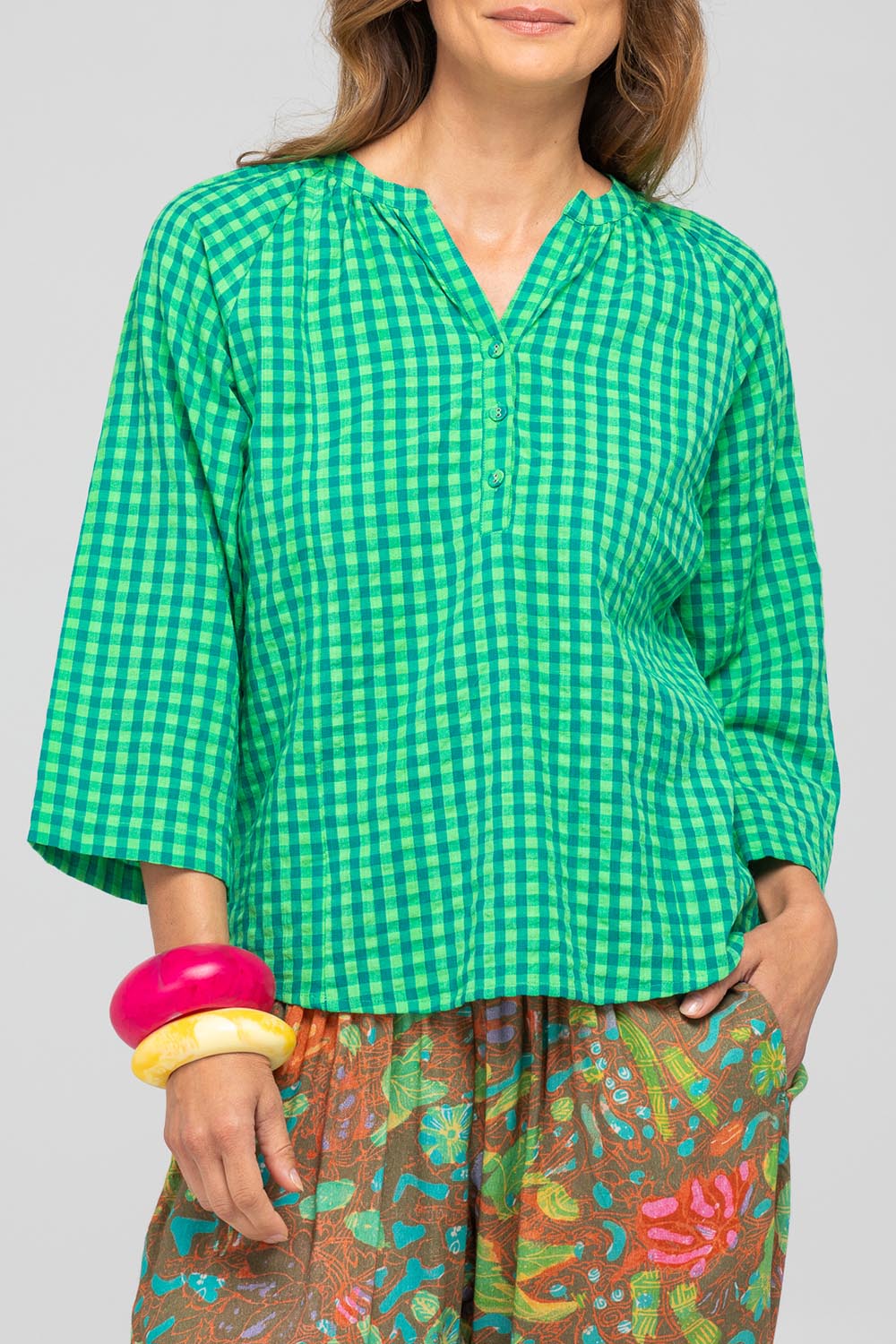 A model wearing the Cecilia Cotton Top in colour Verde (Green), from the front, cropped image