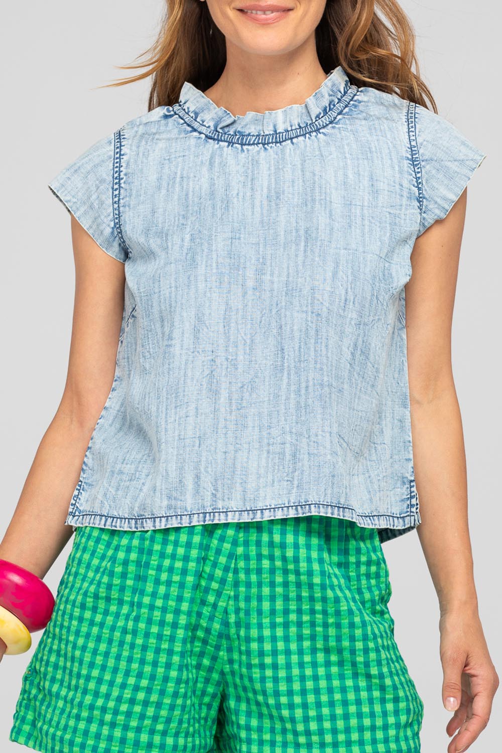 A model wearing the Sand Lyocell Top in colour Comodo (Blue), from the front, cropped image
