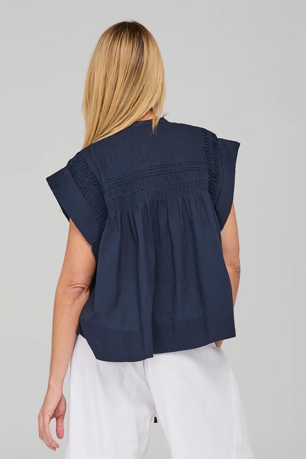A model wearing the Danika Cotton Top in colour Navy (Blue), from the back