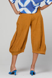 Model Genericm wearing size sample of the Guru Pant – Turmeric in colour Turmeric, from the back