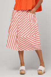Model Genericm wearing size sample of the Guru Skirt – Watermelon in colour Watermelon, from an angle