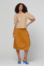 Model Genericm wearing size sample of the Guru Skirt – Turmeric in colour Turmeric, from the front