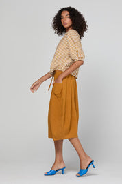 Model Genericm wearing size sample of the Guru Skirt – Turmeric in colour Turmeric, from the front