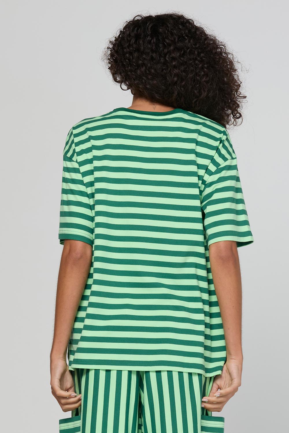Model Genericm wearing size sample of the Luka Tee – Kiwi in colour Kiwi, from the back