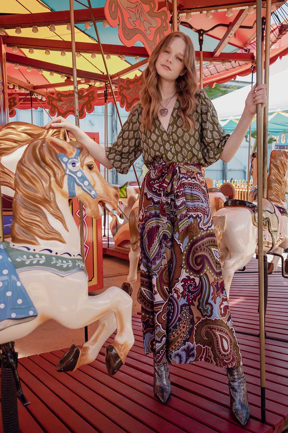 A model wearing the Quincy Pant in colour Juniper (Green), from the front, showing the whole outfit