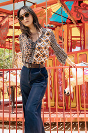 A model wearing the Anne Top in colour Siennaspli (Black), from the front, showing the whole outfit