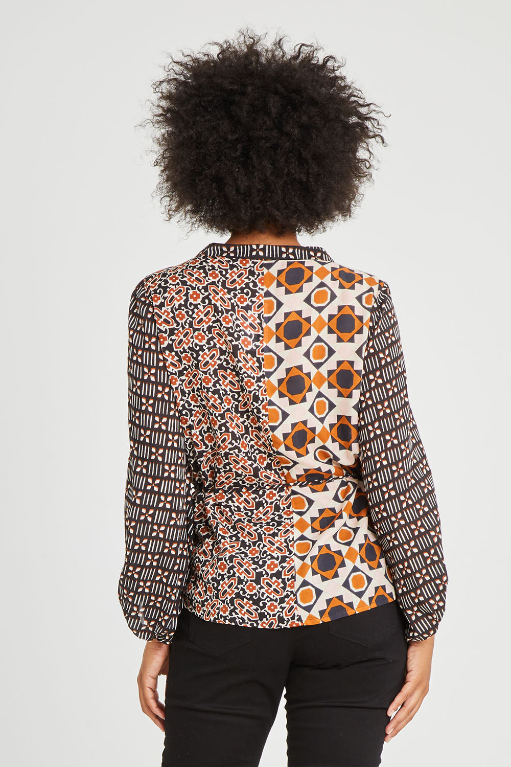 Model Olivia wearing size 10 of the Anne Top in colour Siennaspli (Black), from the back