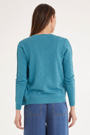 Model Madeline wearing size S of the Lora Cardigan in colour Blue (Blue), from the back