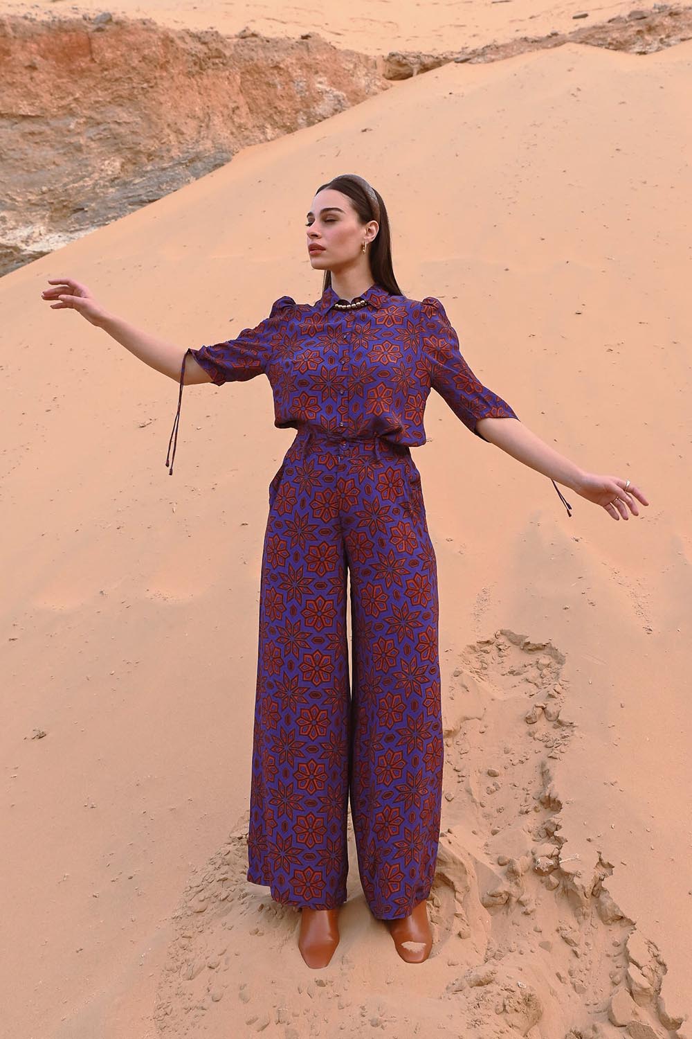 A model wearing the Sara Pant in colour Rio (Purple), from the front, showing the whole outfit