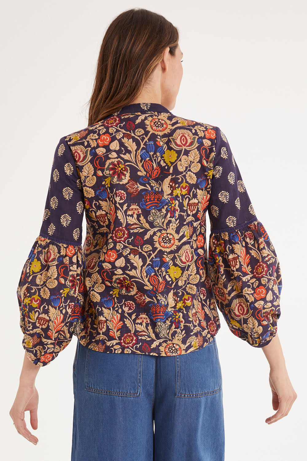 Model Madeline wearing size 10 of the Mittee Top in colour Cella (Blue), from the back