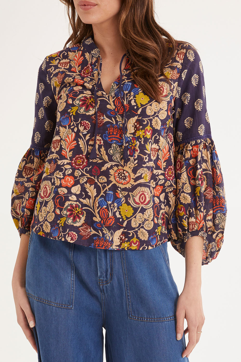 Model Madeline wearing size 10 of the Mittee Top in colour Cella (Blue), from the front, cropped image