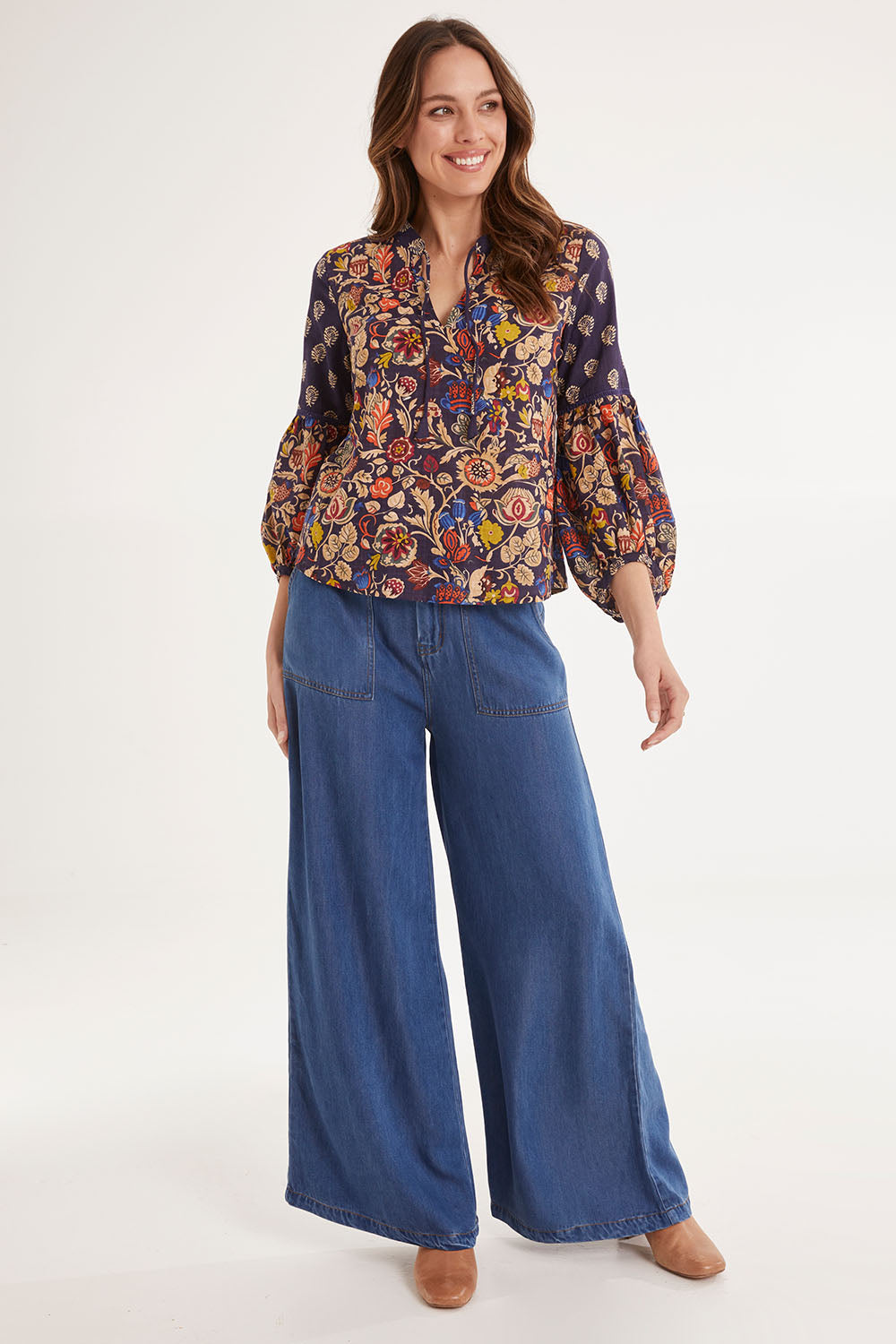 Model Madeline wearing size 10 of the Mittee Top in colour Cella (Blue), from the front, showing the whole outfit