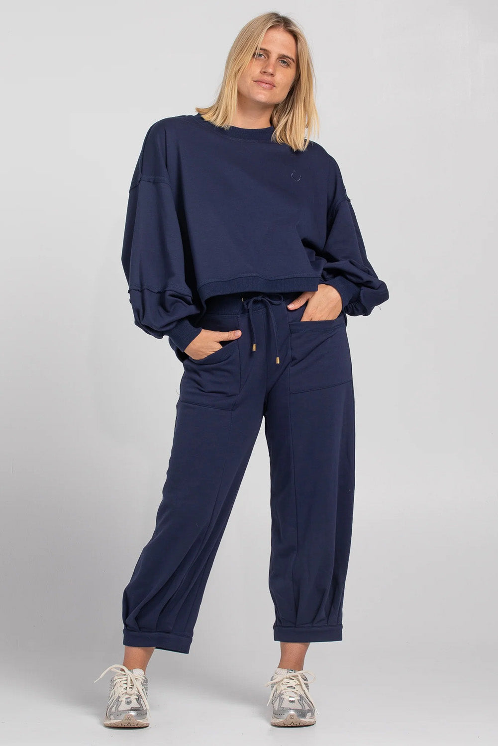 A model wearing the Guru Cotton Blend Sweater in colour Navy (Blue), from the front, showing the whole outfit
