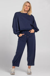 A model wearing the Guru Cotton Blend Sweater in colour Navy (Blue), from the front, showing the whole outfit